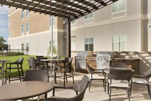 un patio con mesas y sillas frente a un edificio en Homewood Suites Mobile en Mobile