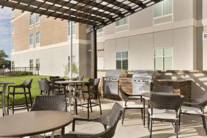 a patio with tables and chairs in front of a building at Homewood Suites Mobile in Mobile