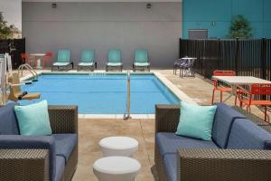 una piscina con sillas, una mesa y una mesa en Tru By Hilton El Paso Northeast, en Homestead Meadows South