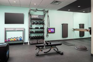 a room with a gym with a bench and weights at Tru By Hilton El Paso Northeast in Homestead Meadows South