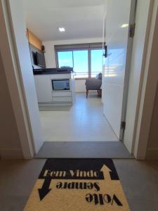 een hal met een keuken en een pijlbord op de vloer bij Lindo Studio NOVO no JP Redenção - Rofftop com vista espetacular in Porto Alegre +26 foto's