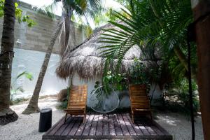 two chairs sitting on a wooden deck in front of a house at Hotel Casa Barbara Holbox in Holbox Island