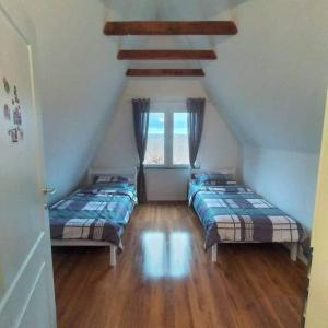 a attic room with two beds and a window at Villa Piano - Cheerful 3-bedroom villa with BBQ grill in Novoberdo