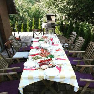 une longue table avec des assiettes de nourriture dans l'établissement Villa Piano - Cheerful 3-bedroom villa with BBQ grill, à Novoberdo