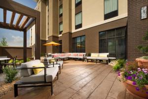 un patio avec des canapés et des tables en face d'un bâtiment dans l'établissement Hampton Inn Louisville East Hurstbourne, à Louisville