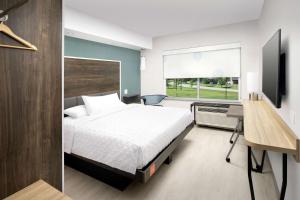 1 dormitorio con cama, escritorio y ventana en Tru By Hilton Louisville East Ky, en Louisville