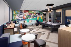 um quarto com uma mesa de pingue-pongue e um mural em Tru By Hilton Tallahassee Central em Tallahassee