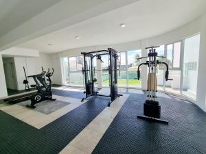 a gym with two treadmills and two exercise bikes at Areias do Mar 2 Quartos, Charmoso e Completo in Barra de São Miguel