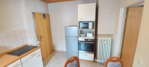 a small kitchen with a refrigerator and a microwave at Apartment Popp Langen in Langen