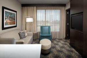 a living room with a couch and a chair and a television at Embassy Suites by Hilton Knoxville West in Knoxville