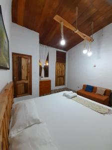 a bedroom with a large white bed and wooden ceilings at Sky Blue Hospedaje in Puerto Villamil