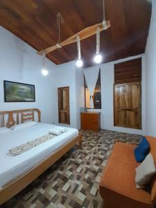 a bedroom with a large bed and a couch in it at Sky Blue Hospedaje in Puerto Villamil