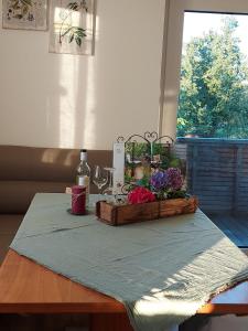 - une table avec une bouteille de vin et des fleurs dans l'établissement Wildkraut´s Kräuterbauernhof - Ferienwohnung, à Kremsmünster
