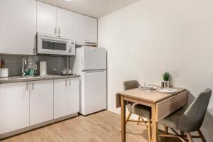 InTown Suites Extended Stay Fort Myers FL في فورت مايرز: مطبخ مع طاولة وثلاجة بيضاء