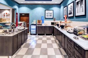 a large kitchen with blue walls and wooden cabinets at Hampton Inn & Suites by Hilton Atlanta Perimeter Dunwoody in Atlanta