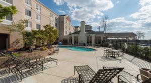 a courtyard with chairs and a pool in a building at Hilton Garden Inn Auburn/Opelika in Auburn