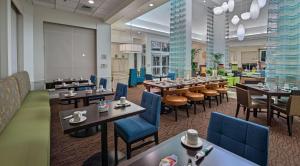 a restaurant with tables and chairs in a room at Hilton Garden Inn Auburn/Opelika in Auburn