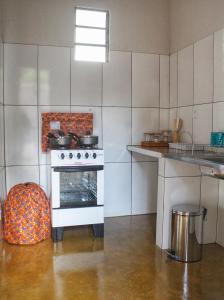 a kitchen with a stove and a chair in it at Bangalôs do Tapajós in Alter do Chao