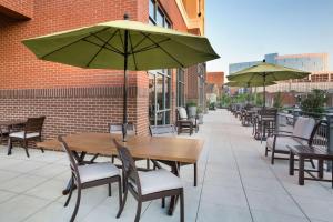 un patio al aire libre con mesas, sillas y sombrillas en Home2 Suites By Hilton Birmingham Downtown, en Birmingham