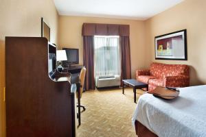 a hotel room with a bed and a couch at Hampton Inn & Suites Laurel in Laurel