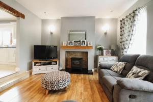 uma sala de estar com um sofá e uma lareira em Tirmacspird Road 
