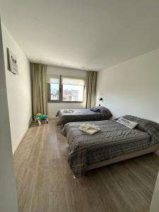 a bedroom with three beds and a window at Depto 3 amb zona Guemes con cochera, balcón a la calle con parrilla a gas in Mar del Plata