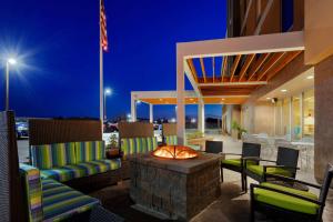 a patio with chairs and a fire pit at night at Home2 Suites by Hilton Baltimore/Aberdeen MD in Aberdeen
