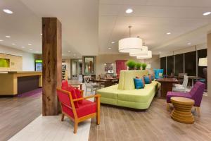 Home2 Suites by Hilton Baltimore/Aberdeen MD في أبردين: لوبى مع كراسي ملونة وغرفة معيشة