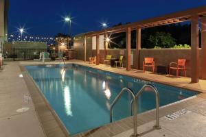 - une piscine éclairée la nuit dans l'établissement Home2 Suites by Hilton Fayetteville, NC, à Fayetteville