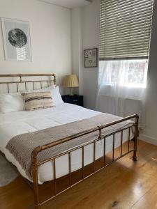 a bedroom with a bed and a window with a window blind at Cosy Shoreditch flat in London