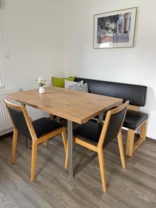 mesa de madera con 2 sillas y sofá en Appartement Pürstinger, en Altenmarkt im Pongau