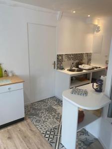 uma pequena cozinha com uma mesa e um lavatório em Maison situee au cœur du pays d auge 