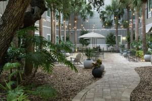 un patio en un edificio con sillas y árboles en Hampton Inn New Smyrna Beach en New Smyrna Beach