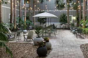 a patio with tables and chairs and plants in a building at Hampton Inn New Smyrna Beach in New Smyrna Beach
