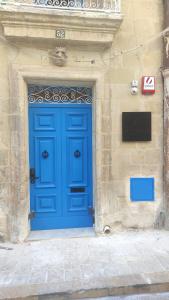 eine blaue Tür an der Seite eines Gebäudes in der Unterkunft Mandera's Boutique Suites & Dorms in Valletta