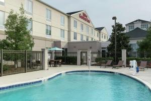 a hotel with a swimming pool in front of a building at Hilton Garden Inn Dothan in Dothan