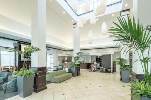 an office lobby with potted plants in the middle at Hilton Garden Inn Dothan in Dothan