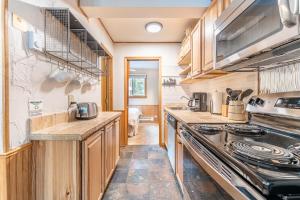 a kitchen with wooden cabinets and a stove top oven at Meticulously Updated Unit With Lots of Thoughtful Upgrades Ski In, Walk to Town PM1B in Breckenridge