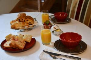 庫謝韋爾尼的住宿－La Halte du Clos，餐桌,带食物盘和橙汁杯