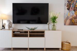 a white entertainment center with a tv on a wall at Lanzahost Casa Juan in Costa Teguise