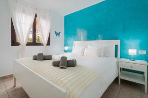 a bedroom with a large white bed with a blue wall at Lanzahost Casa Juan in Costa Teguise