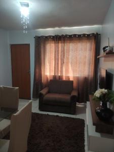 里奥韦尔迪Apto Recanto Aconchego (B-E 32)的客厅里，窗前有一张沙发