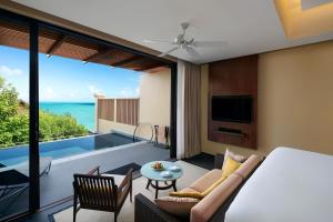 a room with a bed and a view of the ocean at Vana Belle, A Luxury Collection Resort, Koh Samui in Chaweng Noi Beach