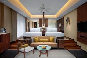 a hotel room with two beds and a couch at Vana Belle, A Luxury Collection Resort, Koh Samui in Chaweng Noi Beach
