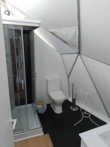 a bathroom with a toilet and a shower in a tent at Forest Domes in Setúbal
