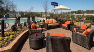 a patio with chairs and a table with an umbrella at Hilton Garden Inn Huntsville/Space Center in Huntsville