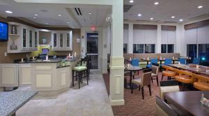 a restaurant with tables and chairs and a bar at Hilton Garden Inn Huntsville/Space Center in Huntsville