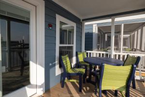 um alpendre com uma mesa e cadeiras numa varanda em Blufin Bungalows & Marina em Chincoteague