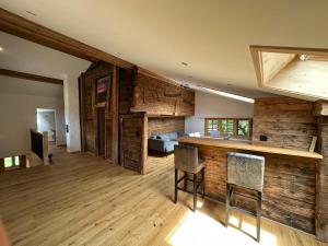 Chalet Brünig في ميرينغين: غرفة كبيرة بجدران خشبية وغرفة نوم