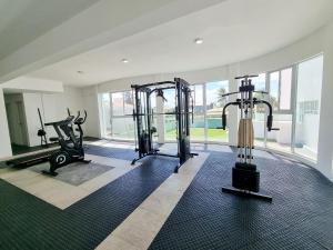 a gym with two treadmills and two exercise bikes at Areias do Mar ! 3 quartos com Varanda A212 in Barra de São Miguel